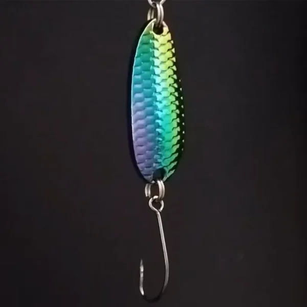 Suckerme Rainbow Flashback Spoon 5g i regnbuefinish med skælstruktur og enkeltkrog, hængende mod sort baggrund.