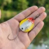 Magic Trout Bloody Blades 2,1g - Størrelse Magic Trout Bloody Blades 2,1g holdt i en hånd for at vise den kompakte størrelse. Et ideelt microblink til UL-fiskeri i Put & Take.